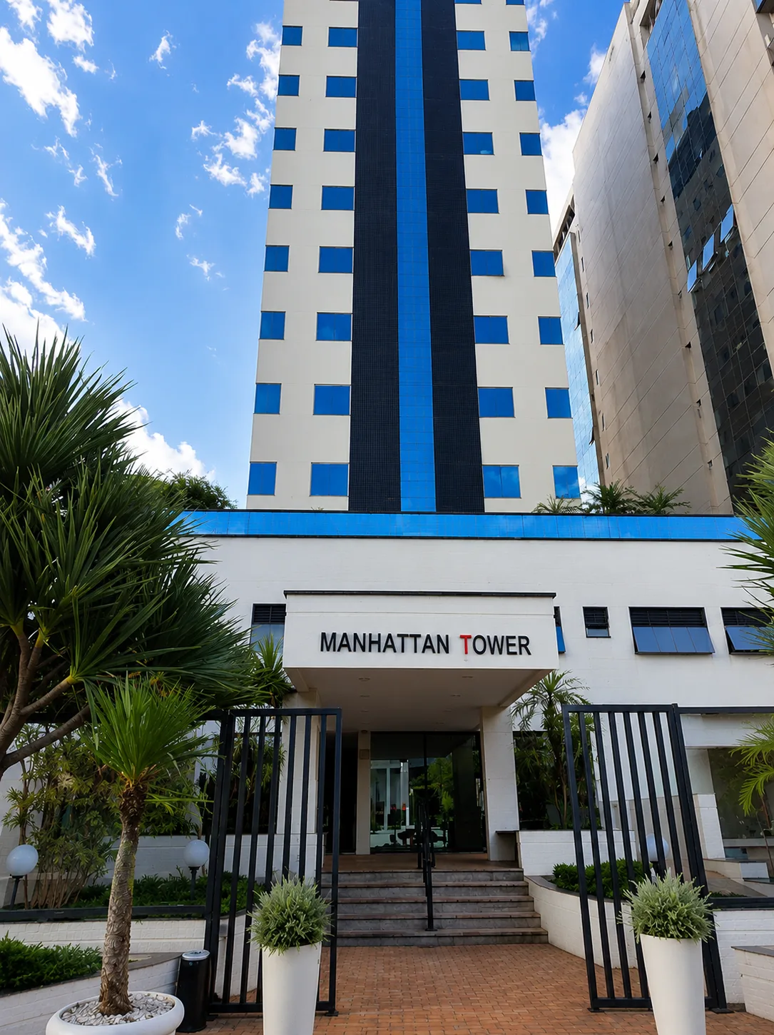 Fachada do edifício Manhattan Tower com entrada principal e paisagem urbana