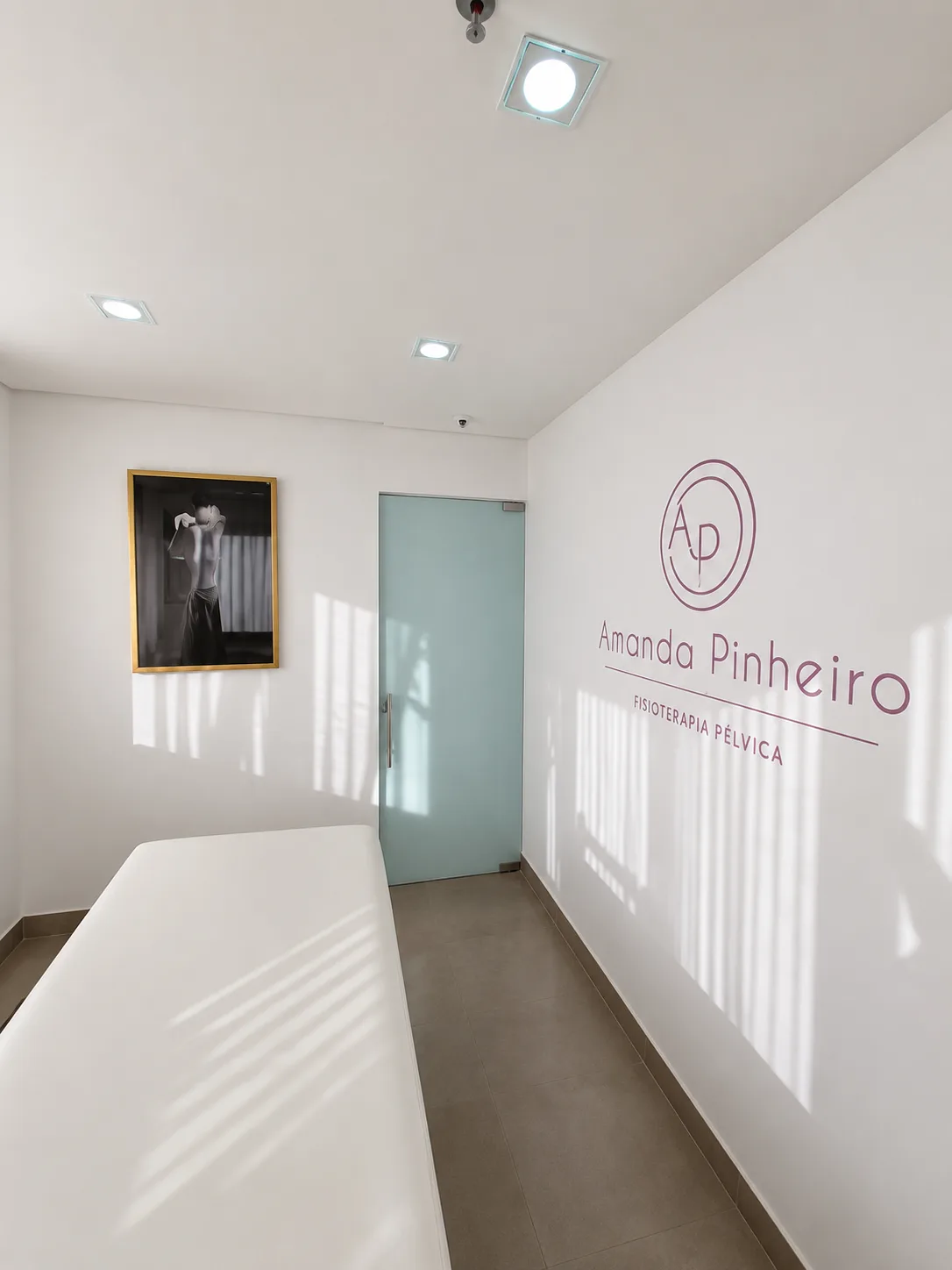 Corredor interno com logotipo Amanda Pinheiro Fisioterapia Pélvica, porta verde e ambiente profissional